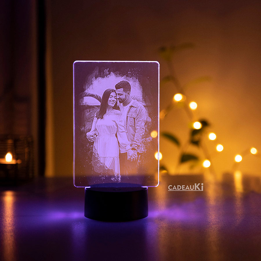 Sfeervolle gepersonaliseerde LED-fotolamp met paarse gloed en decoratieve achtergrond.